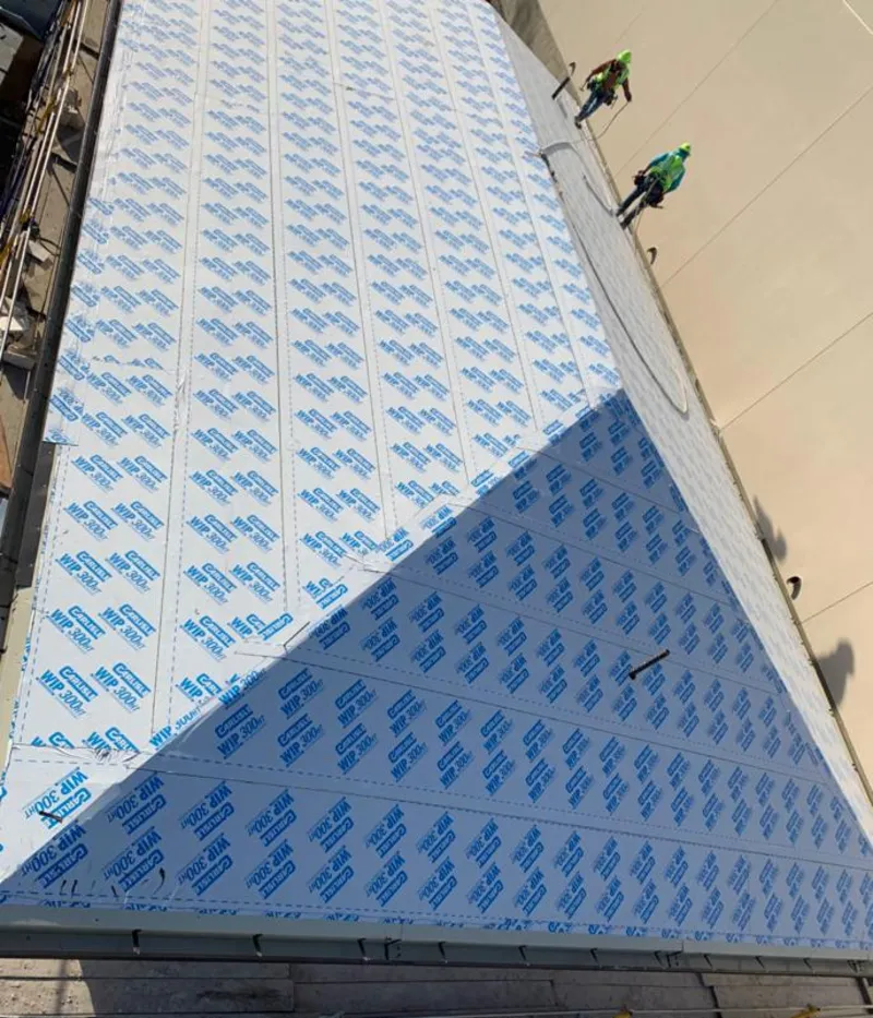 Professional roofers installing underlayment on a metal roof in Hornell